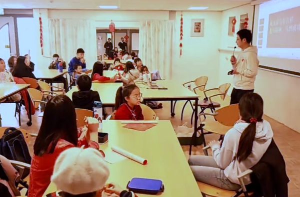 学生和家长坐在长桌旁听讲解